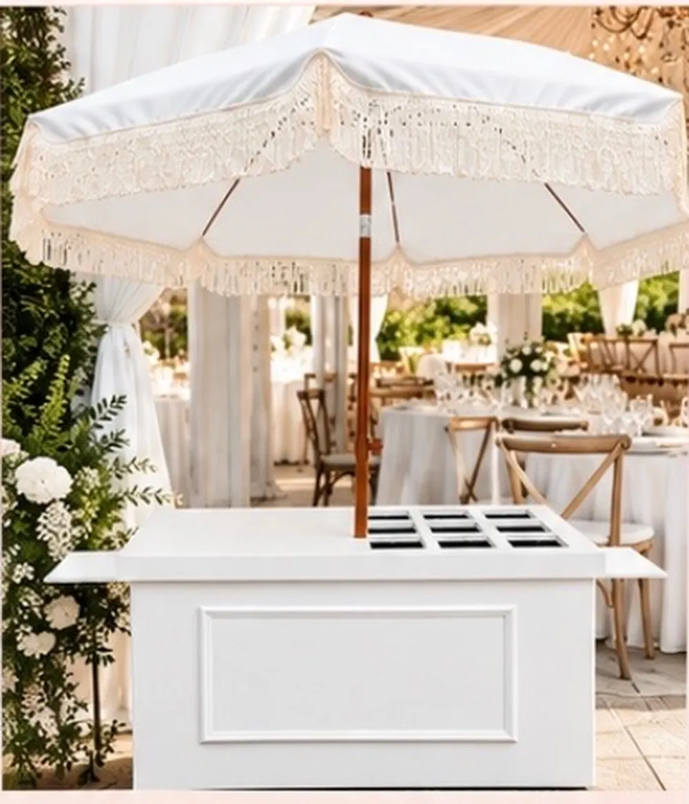 Signature white cart with a large fringed umbrella and cutout top